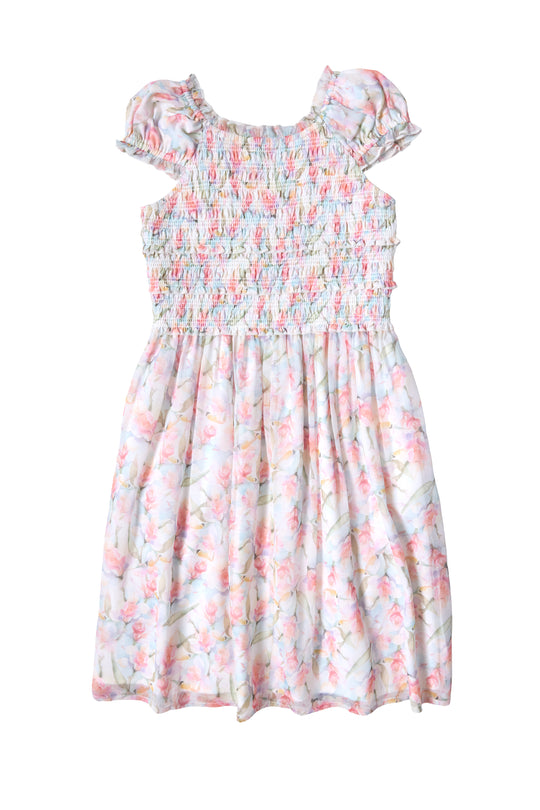The Ivy City Co Mini Kyla Dress in Watercolor Orchids features a light chiffon design with short puff sleeves, a smocked bodice, and a flared skirt. Soft pastel florals bloom on white for a sweet look.