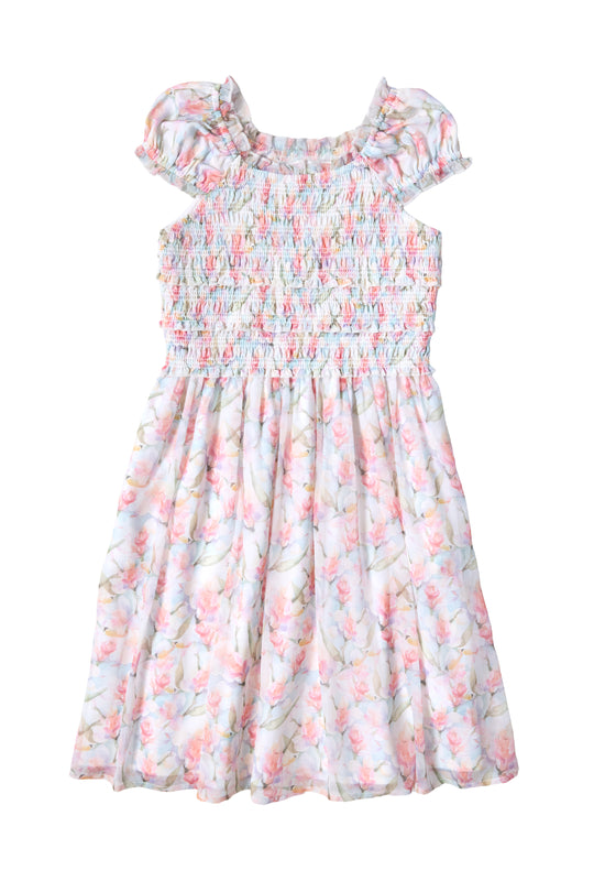 Ivy City Co’s Mini Kyla Dress in Watercolor Orchids features a smocked bodice, ruffled neckline, puff sleeves, and a flowy A-line skirt with pastel orchid prints—perfect for any special occasion.