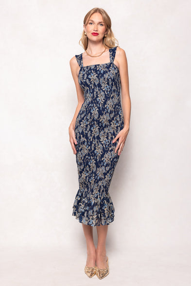 Woman wearing a navy floral dress on a white background