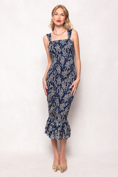 Woman wearing a navy floral dress on a white background