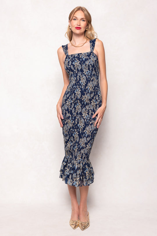 Woman wearing a navy floral dress on a white background