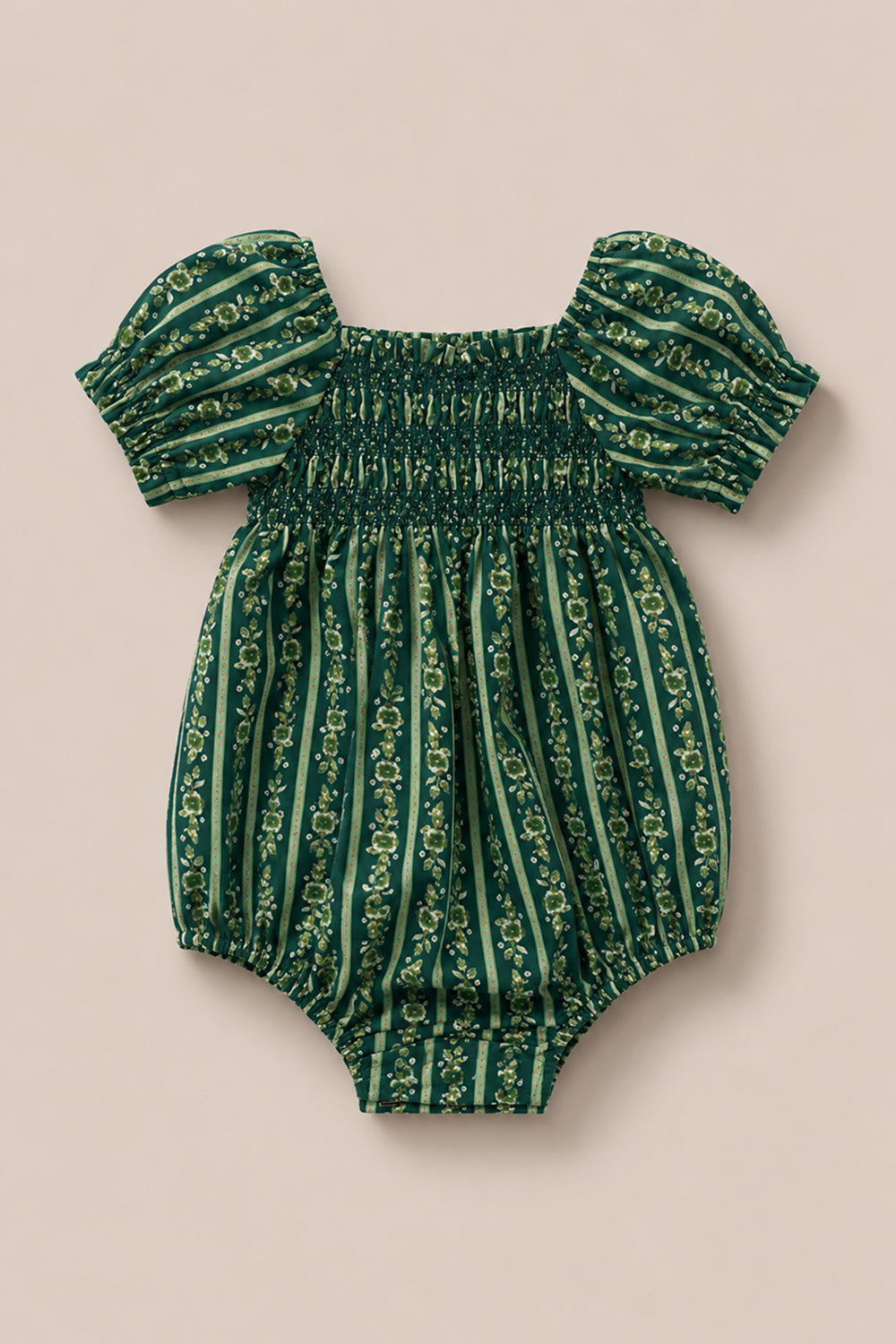 The Ivy City Co Baby Sunday Best Romper in Pine Felicity Floral features short puff sleeves, a gathered chest, and elastic leg openings. Crafted from fabric with vertical stripes and a delicate Pine Felicity Floral print, the romper is displayed on a beige background.