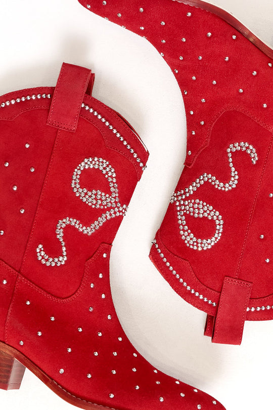 The Channing Bootie in Red by Ivy City Co is a stunning pair of red suede cowboy booties adorned with silver rhinestones in swirling patterns and dots, making a dazzling statement shoe, beautifully displayed on a light background.