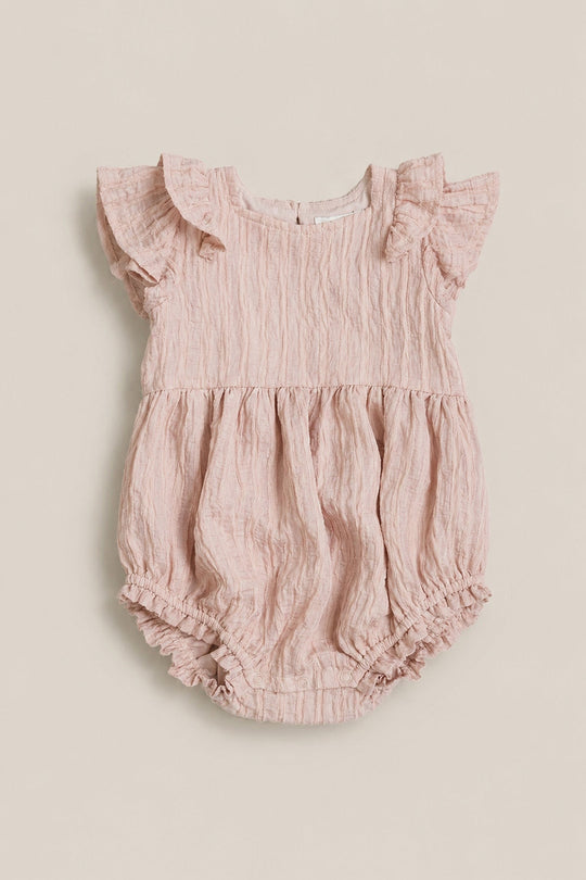 The Baby Hattie Romper in Pink Stripes by Ivy City Co features short ruffled sleeves, a gathered waist, and charming ruffled leg openings. The crinkled fabric adds a sweet touch, while a small button closure at the back makes dressing easy. Pair with Mom and Me matching outfits from Ivy City Co for an adorable coordinated look.