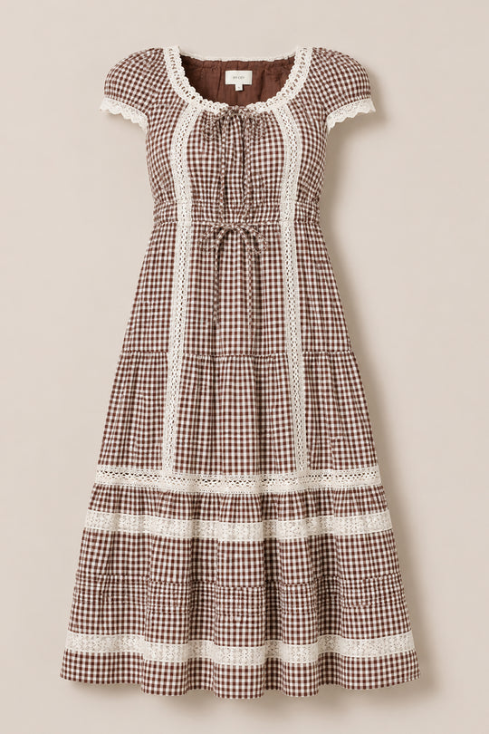 The Palermo Dress in Hickory Gingham by Ivy City Co features a brown and white gingham pattern with short puff sleeves, lace trim, a gathered waist, and a tiered skirt. Displayed on a neutral background, this maternity-friendly dress ensures comfortable style at every stage.