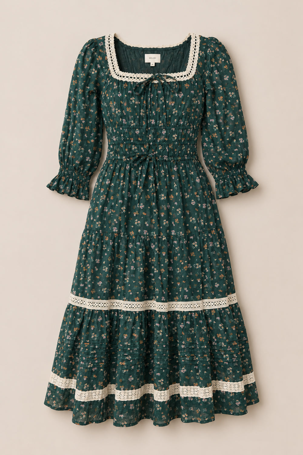 The Palermo 3/4 Sleeves Dress in Evergreen Lovelorn Ditsy by Ivy City Co is a green, floral-patterned cotton midi dress featuring puffed 3/4 sleeves, a smocked bodice, lace trim on the square neckline and skirt, as well as a ruffled hem and cuffs. Maternity friendly for comfortable elegance at every stage.