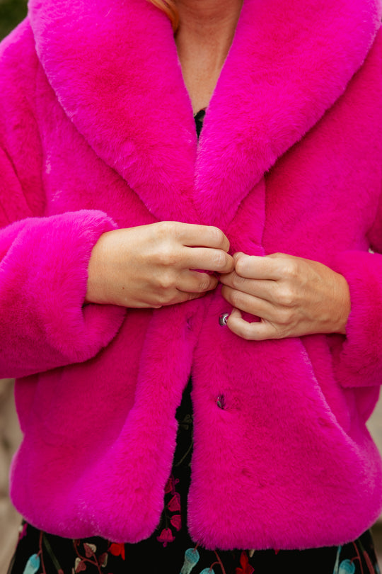 Close-up of a bright pink coat with a blurred background