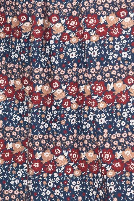 Floral patterned fabric with red, pink, and white flowers on a blue background