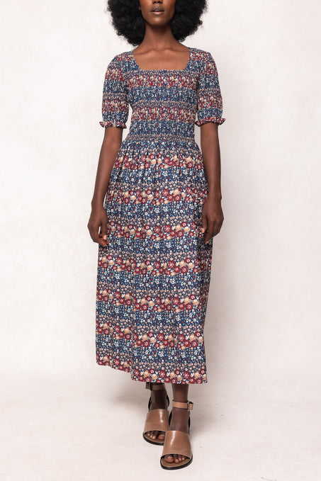Woman wearing a patterned dress on a white background