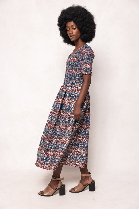 Woman wearing a patterned dress against a white background