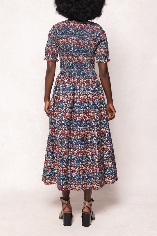 Person wearing a patterned dress on a white background
