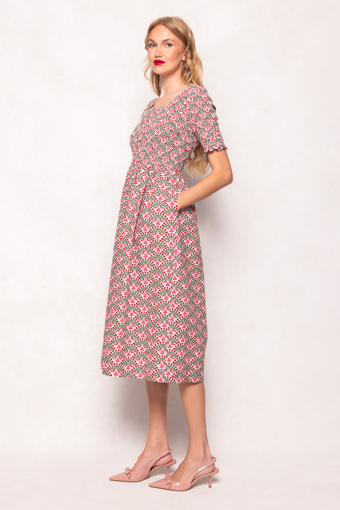 Woman wearing a patterned dress on a plain background