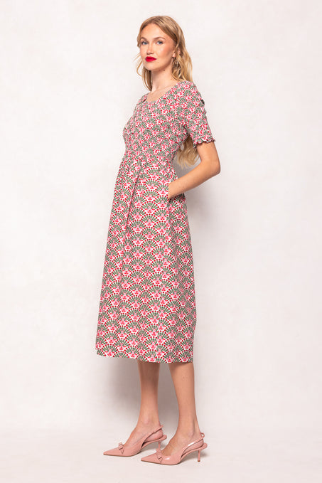 Woman wearing a patterned dress on a plain background