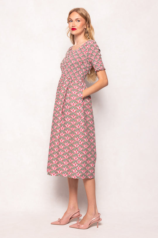 Woman wearing a patterned dress on a plain background