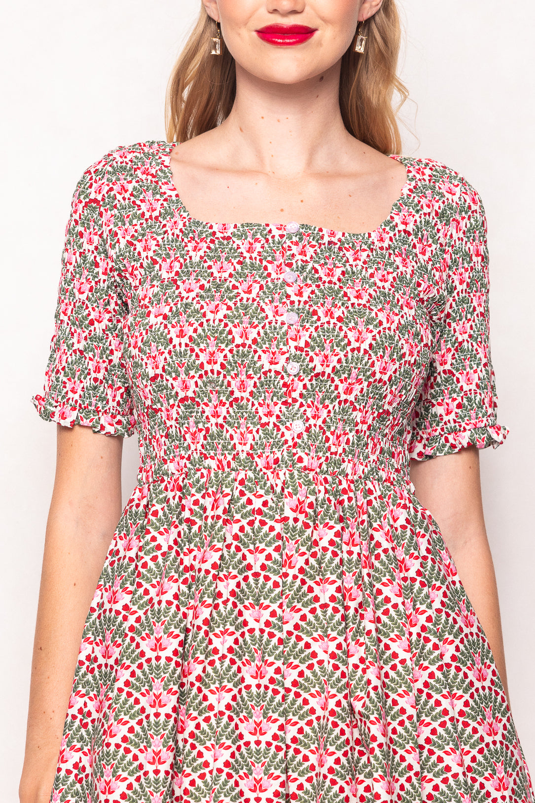 Woman wearing a floral dress with a plain background