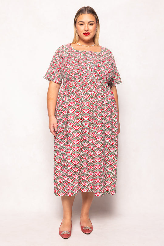 Woman wearing a patterned dress on a white background