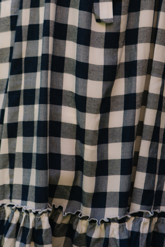 Close-up of the Ivy City Co Picnic Dress in Navy Gingham, featuring a soft, lightweight fabric with a classic checkered pattern and a ruffled hem.
