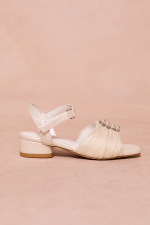The Mini Piper Pearl Heel in Ivory by Ivy City Co is a vegan leather sandal with a low block heel, Velcro ankle strap, and gathered toe adorned with pearl-like beads—ideal girls dress shoes for special occasions.