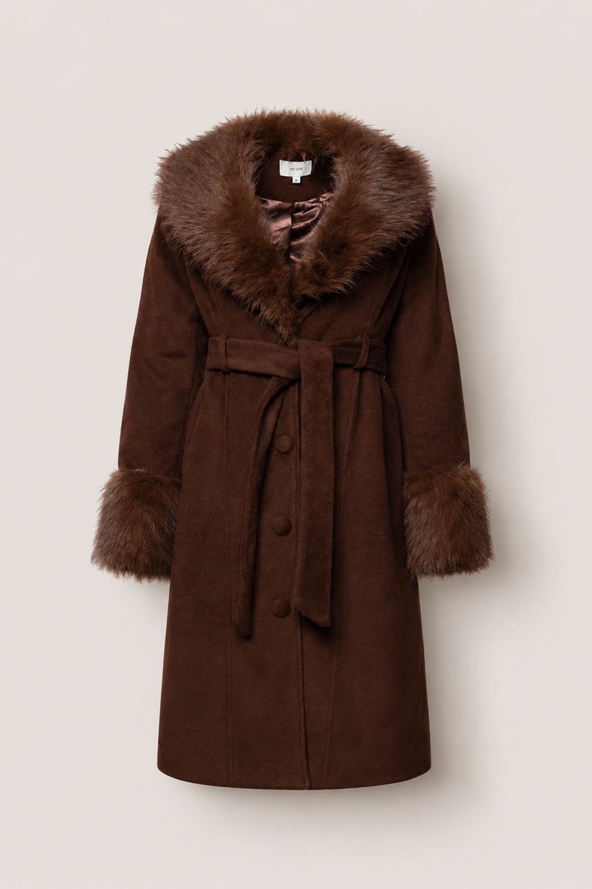 The Pookie Coat in Warm Cocoa by Ivy City Co is a brown suede coat featuring a wide faux fur collar and cuffs, a matching fabric belt at the waist, and button closure down the front, all displayed against a plain light background. Nursing friendly and stylish, this piece seamlessly blends comfort with chic design.