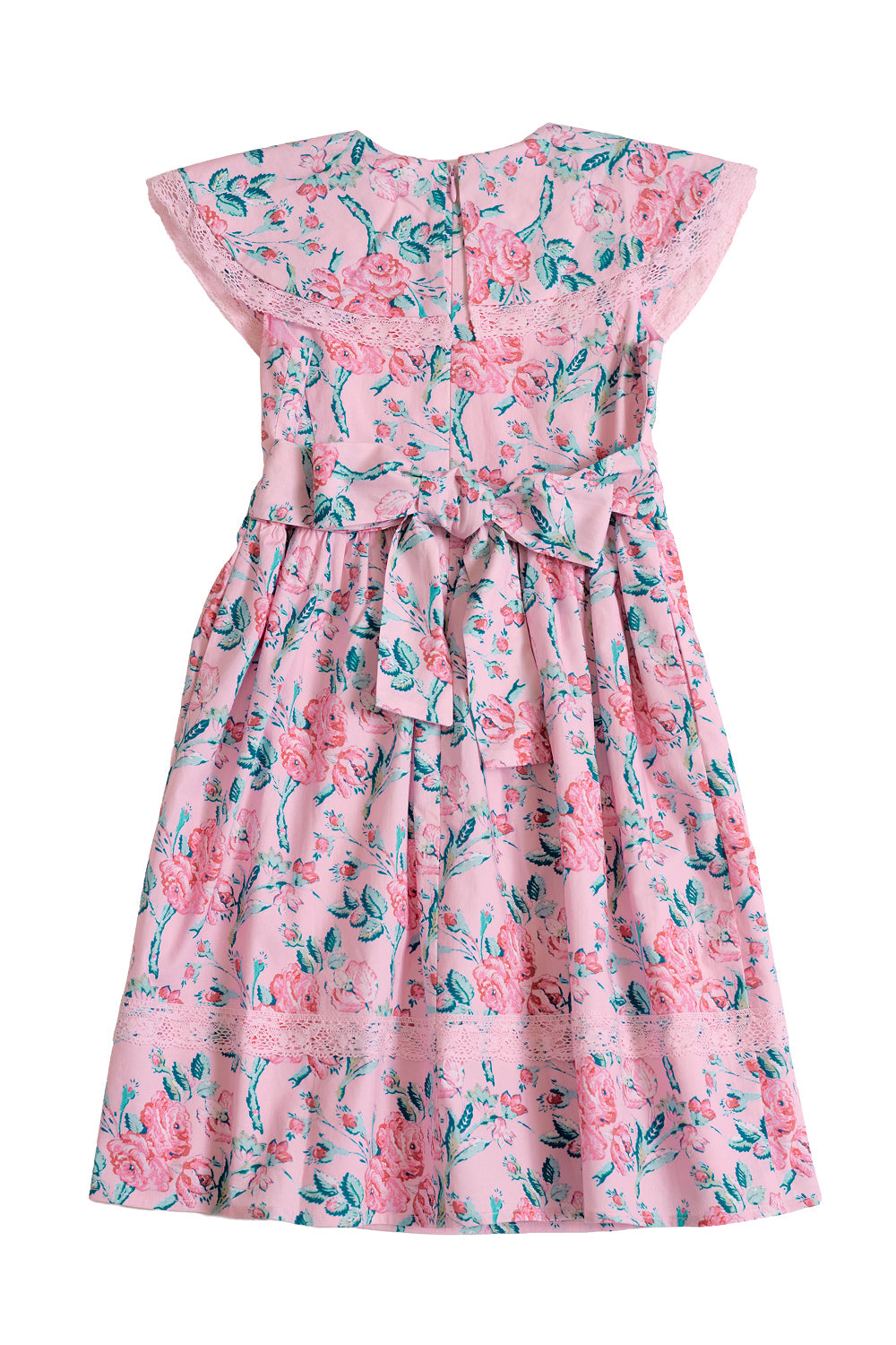 The Mini Aster Dress in Pink Sketched Flower by Ivy City Co features a light pink background adorned with green and pink sketched floral patterns, delicate lace trim, short flutter sleeves, and a charming bow tied at the back—making it an adorable girls’ dress for any special occasion.