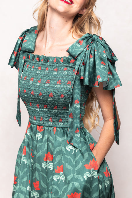 Green floral dress with bow straps worn by a person on a plain background