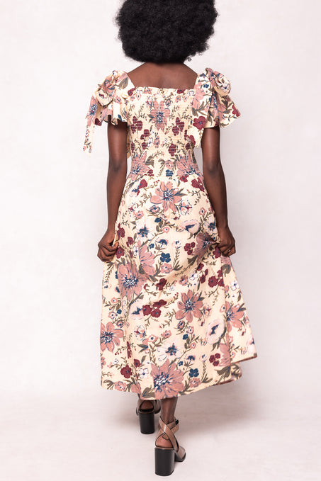 Woman wearing a floral dress with ruffled sleeves on a white background