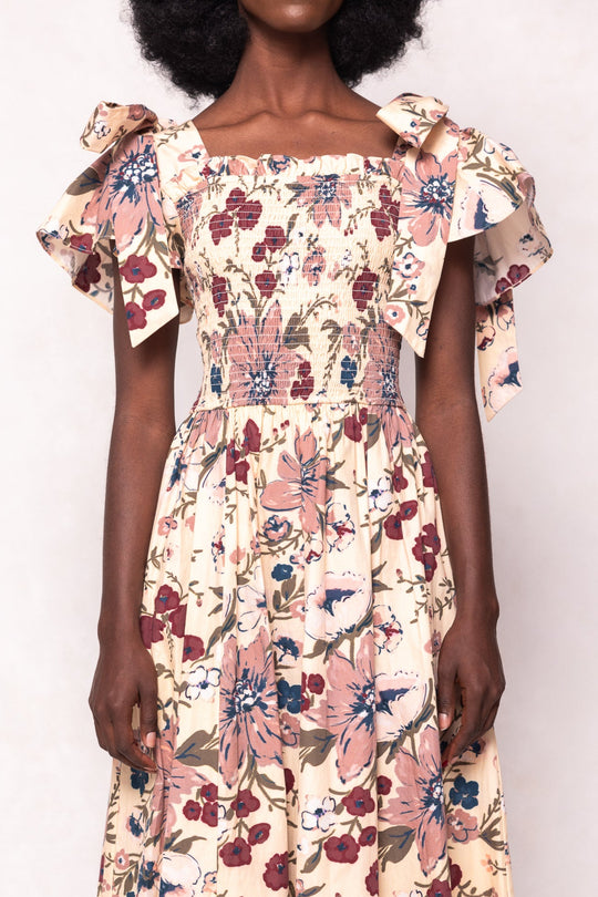 Woman wearing a floral dress with ruffled sleeves on a white background
