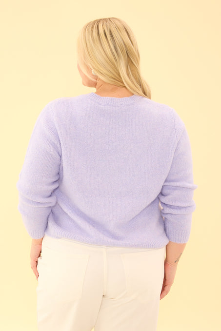Person wearing a light purple sweater on a yellow background