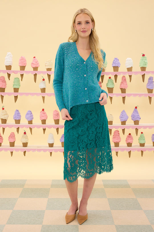 Woman in teal outfit standing in front of an ice cream cone display.