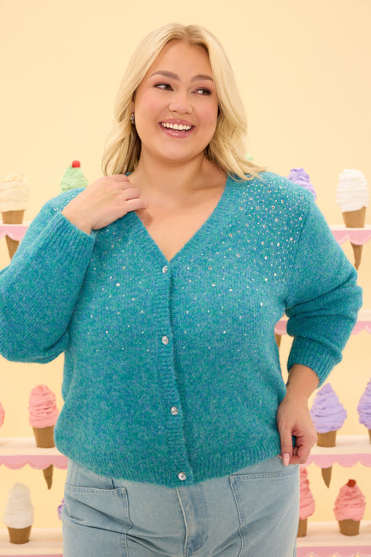 Woman wearing a teal cardigan with ice cream cone background