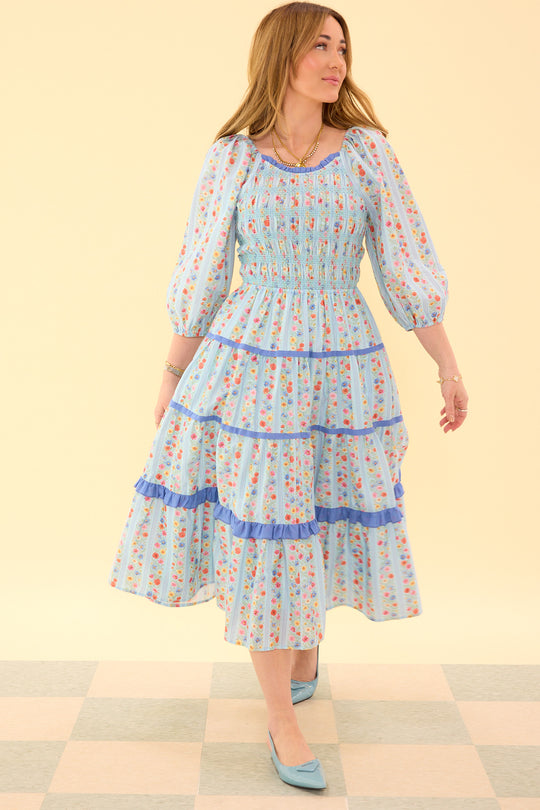 Woman wearing a floral dress with a checkered floor and light yellow wall background