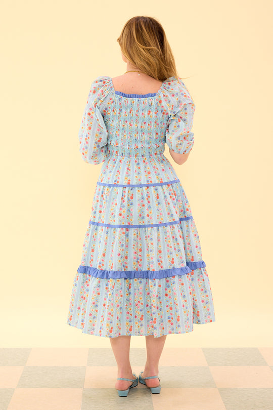 Woman wearing a floral dress with a checkered floor and light yellow wall background