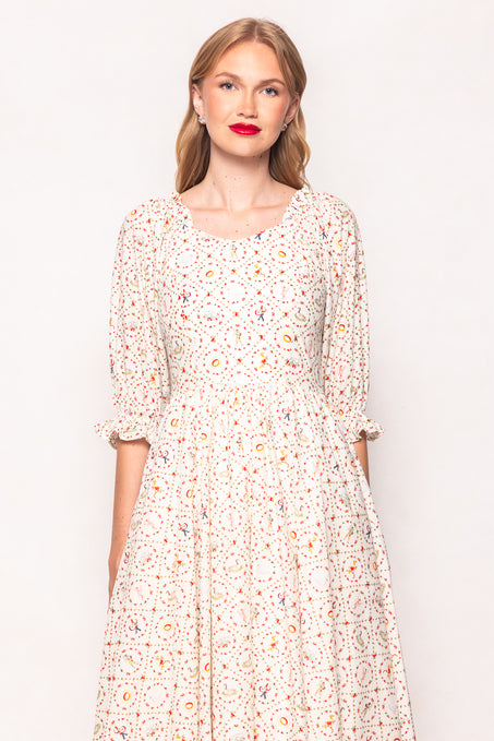 Woman wearing a floral dress against a plain background
