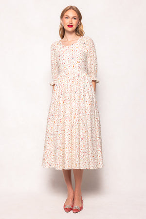 Woman wearing a floral dress against a plain background