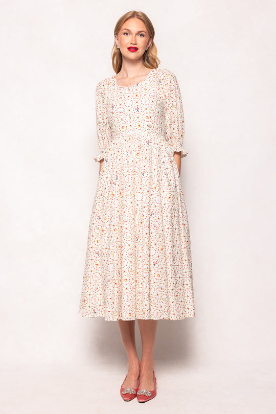 Woman wearing a floral dress against a plain background
