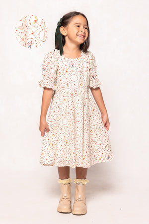 Young girl wearing a floral dress with a white background