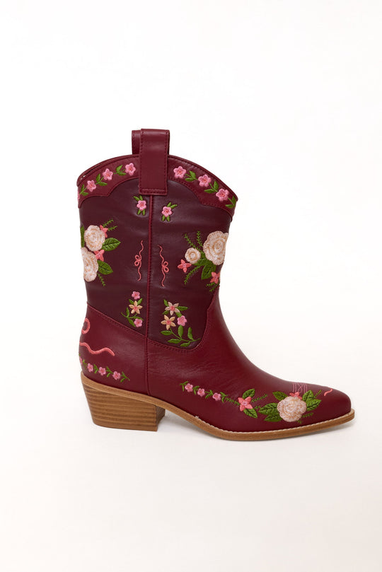 Red cowboy boot with floral embroidery on a white background