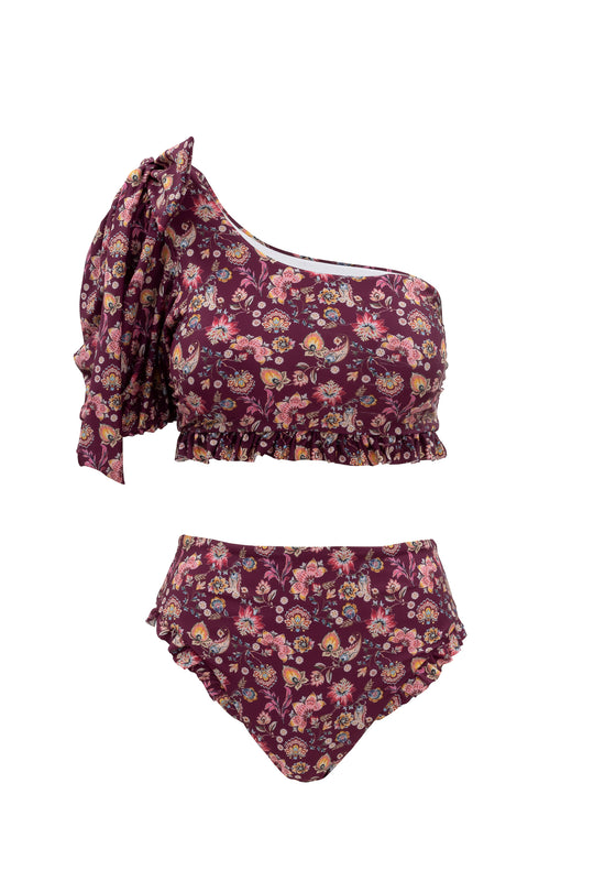 The Ivy City Co Sailor Top in Stephanie Floral is a two-piece swimsuit with a burgundy base, floral one-shoulder top featuring a bow and ruffled hem, paired with high-waisted bottoms finished with playful ruffles.