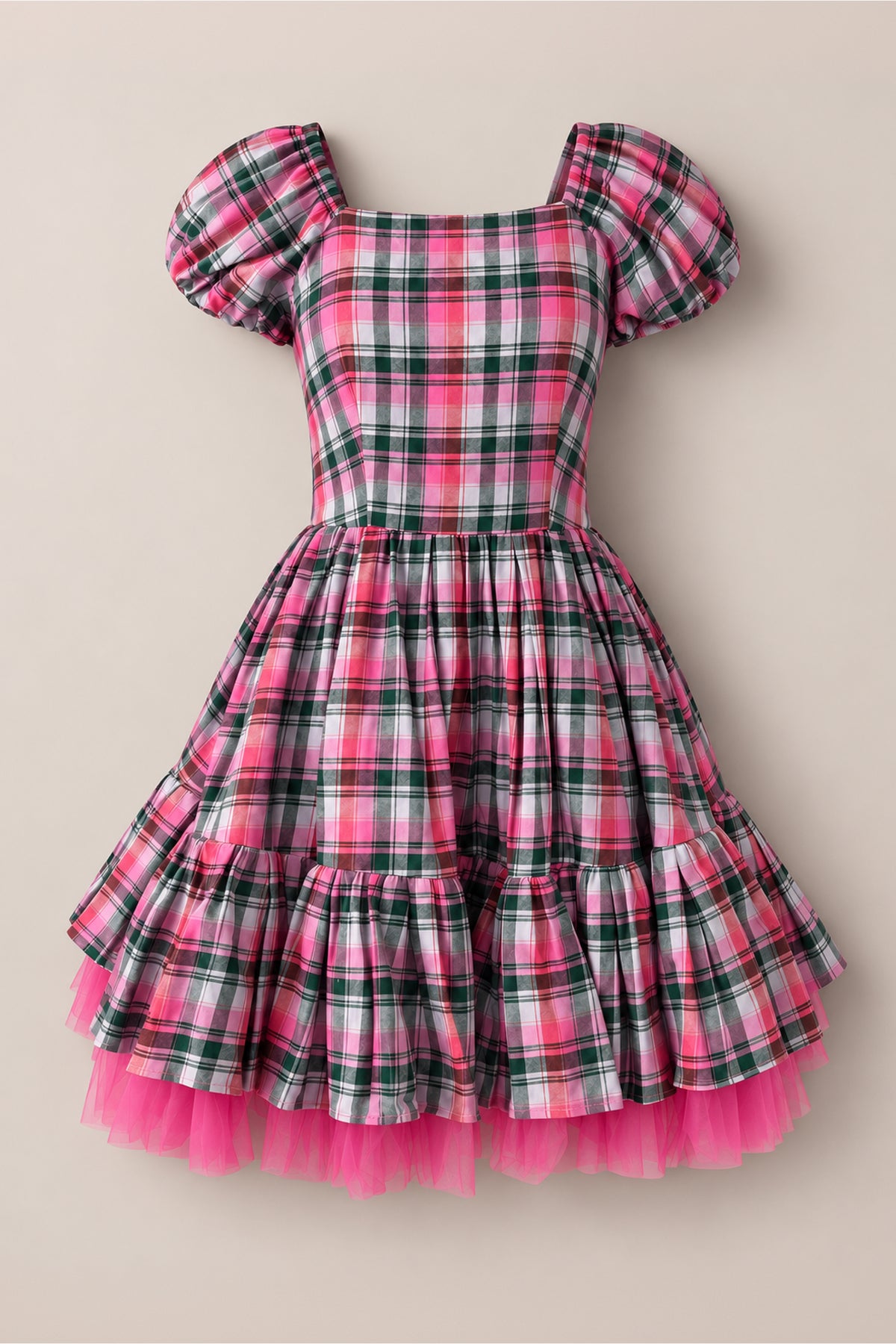The Scottie Dress in Vibrant Plaid by Ivy City Co is a charming short-sleeved holiday party dress crafted from a playful pink, white, and green cotton blend plaid. Featuring puffed sleeves, a fitted bodice, and a flared skirt accented with ruffles, this delightful silhouette is finished with a layer of bright pink tulle peeking out at the hem for an extra festive touch.