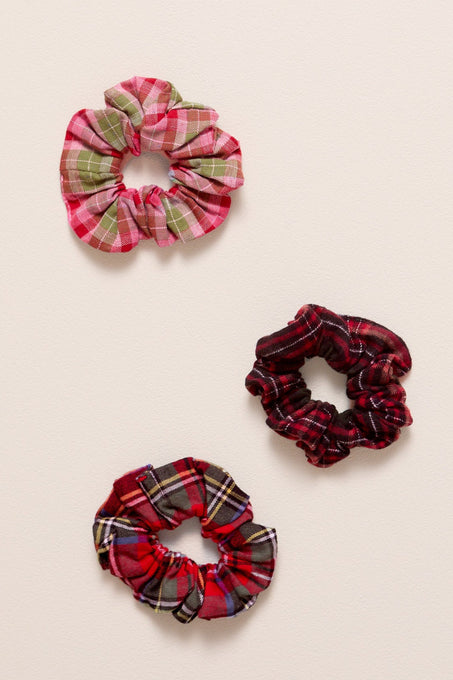 Three plaid scrunchies on a beige background