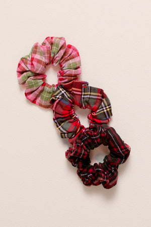 Set of plaid scrunchies on a beige background