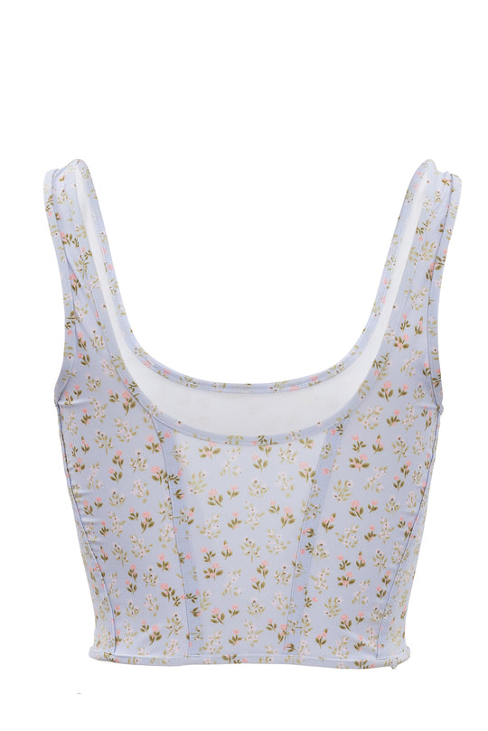The Serena Top in Blue Ditsy Floral by Ivy City Co features a pastel blue base, multicolored ditsy flowers, a scoop neckline, and wide straps—a stylish choice for spandex swimwear fans.