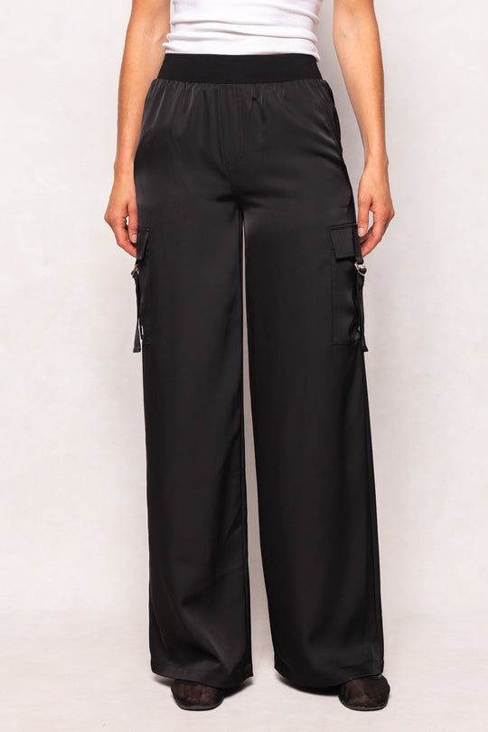 Black cargo pants worn by a person on a white background