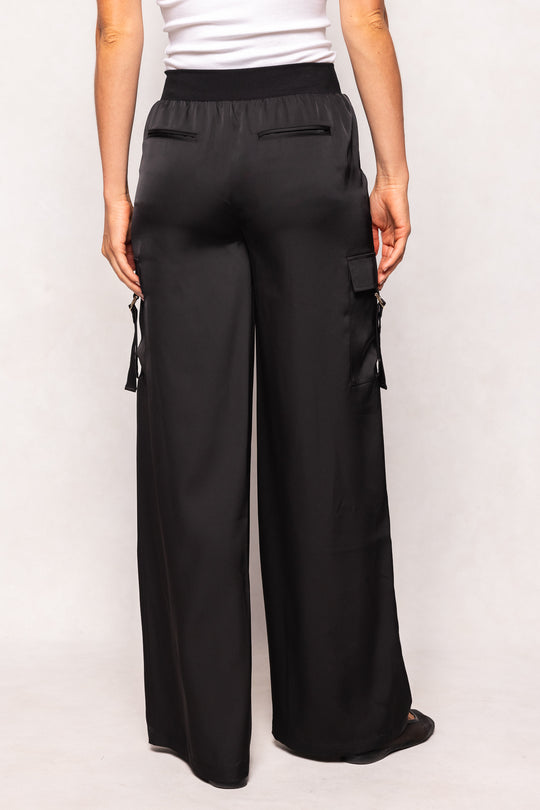 Black wide-leg pants with cargo pockets worn by a person on a white background
