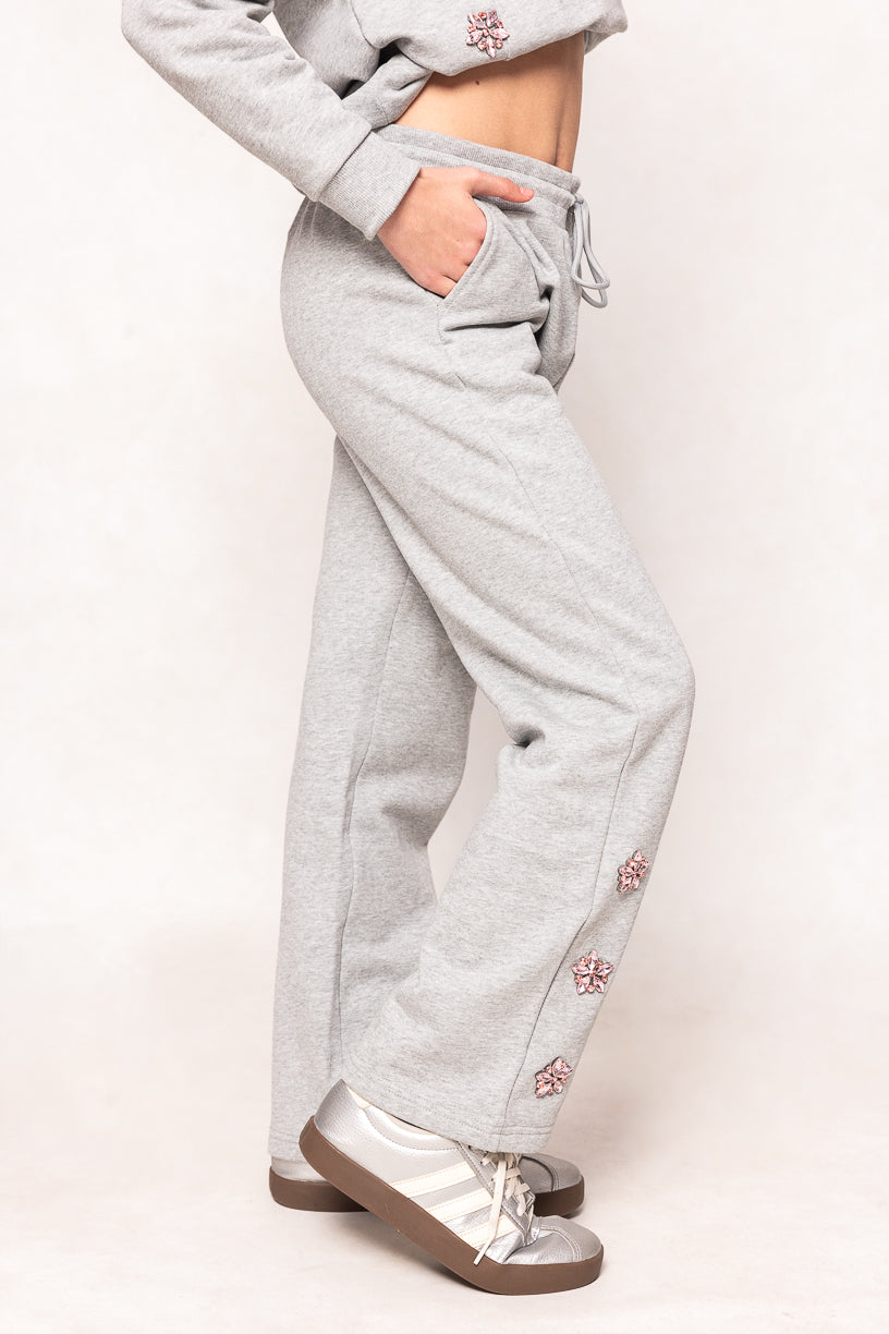 young girl in grey sweatpants against a white background