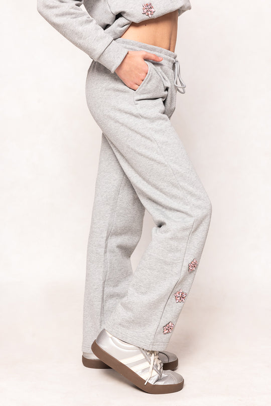 young girl in grey sweatpants against a white background