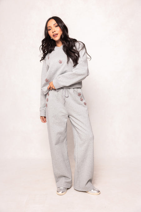 girl in a grey sweatsuit against a white background