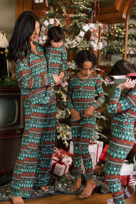 A woman and three children in Ivy City Co So Soft Pajama Set in Alpine Noel stand by a festive Christmas tree. One child wears VR goggles, and a vintage TV sits beside them.