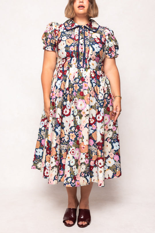 Woman wearing a floral dress against a white background