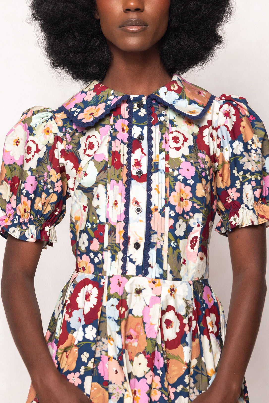 Multicolored floral dress worn by a model on a white background
